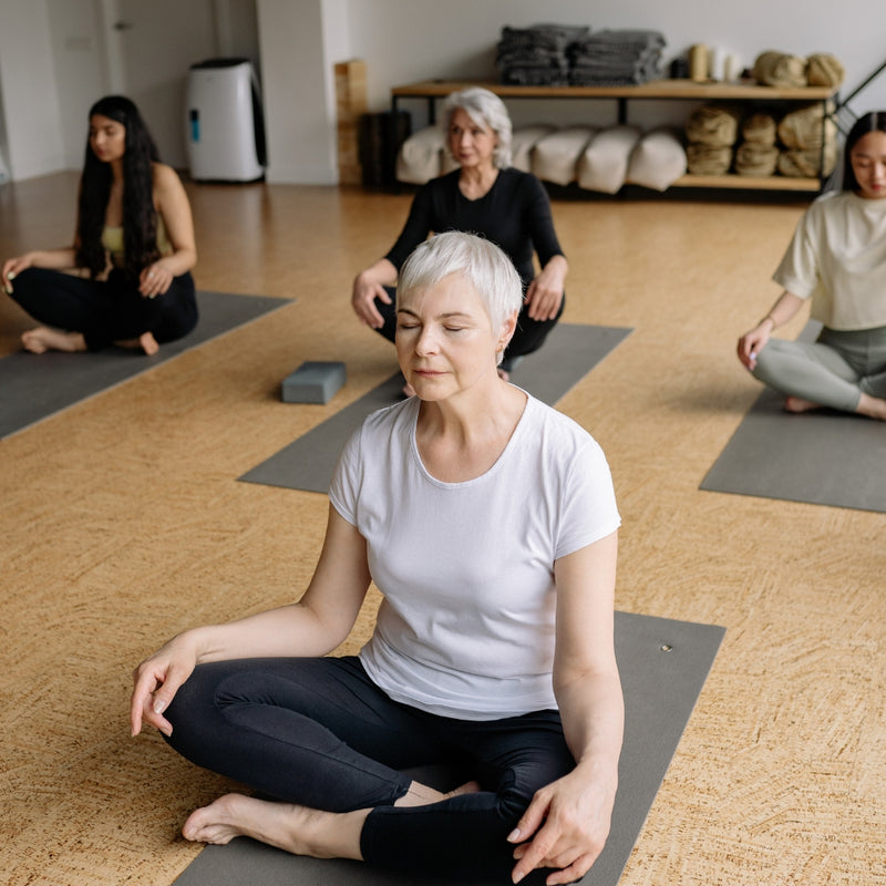 Group of people practicing yoga in a studio setting.